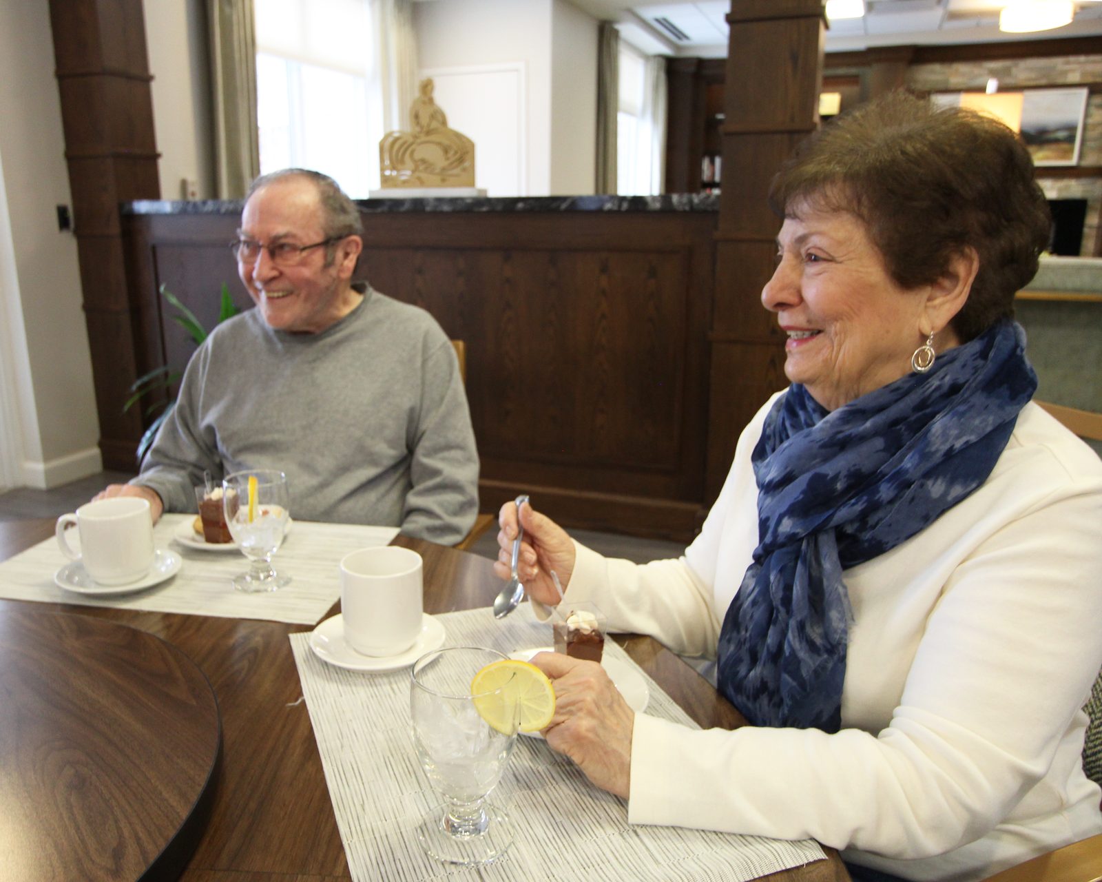 Residents enjoying coffee and dessert together in the Evolve at Lake Zurich lounge