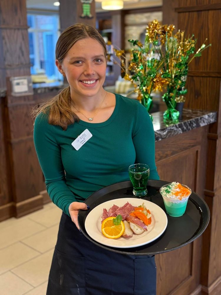 Server presenting a plated meal
